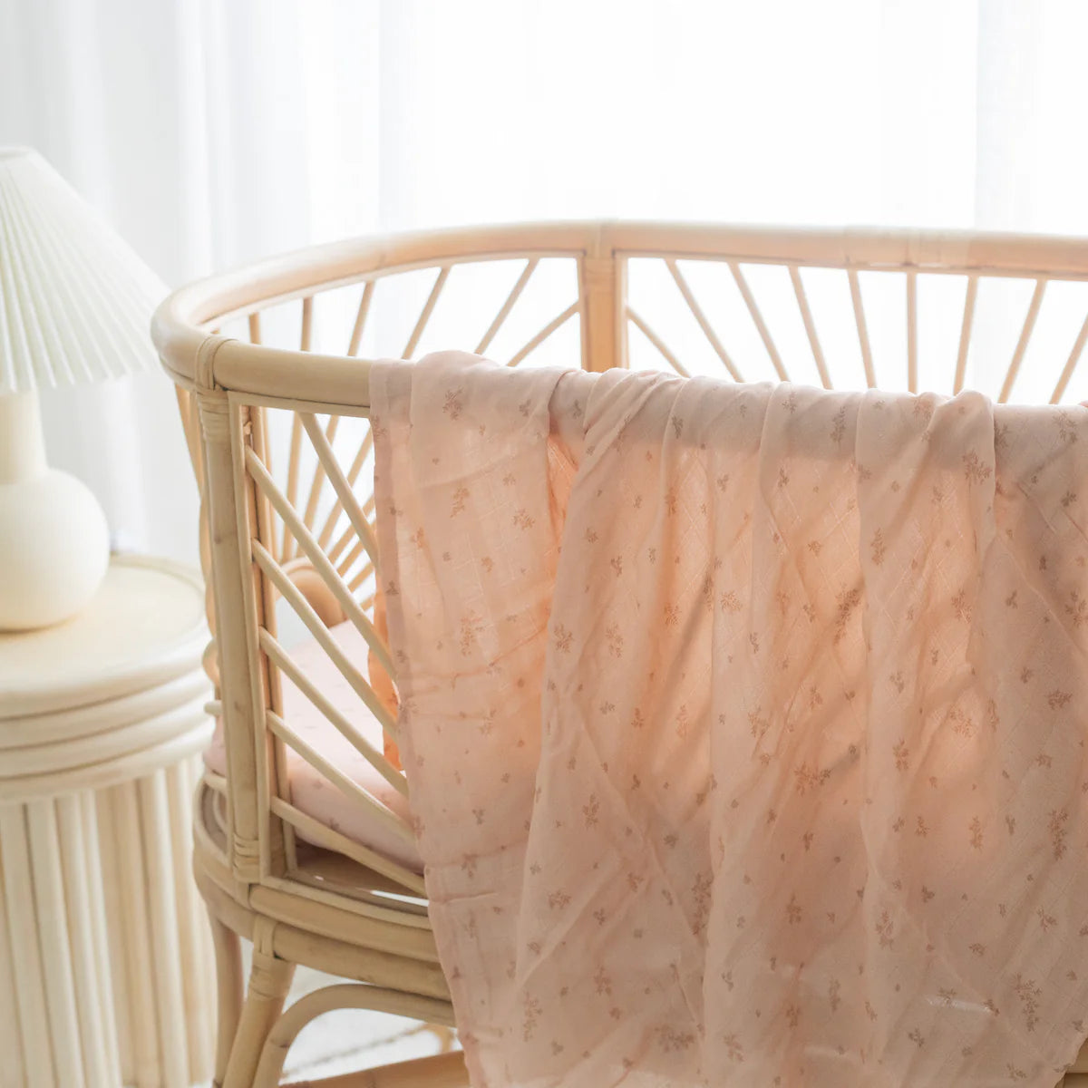 Wild Ruscus muslin swaddle and matching pink BABY journal styled in a rattan bassinet
