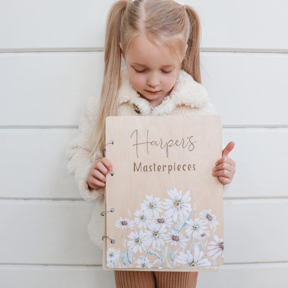 Harper holding her personalised Wild Daisy art binder — children's artwork folder Australia