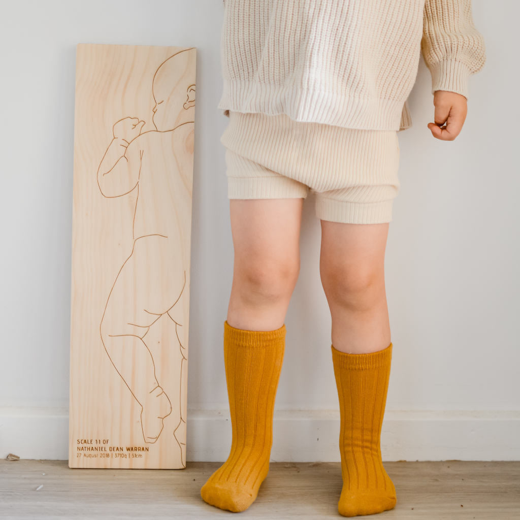 Charliedesignwithtoddler.jpg	Toddler with Charlie personalised birth ruler — shows scale