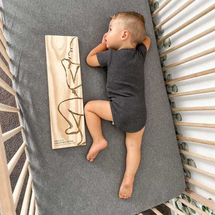 Toddler with Frankie personalised birth ruler — shows scale of wooden keepsake ruler